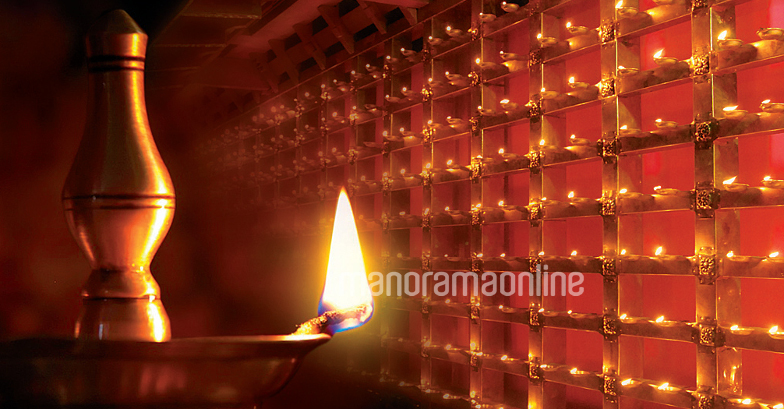 Traditional south indian brass oil lamp 'Nilavilakku '. During events like  housewarming, marriage etc., the Nilavilakku is lighted before starting the  rituals. This picture is taken during a wedding Stock Photo by ©